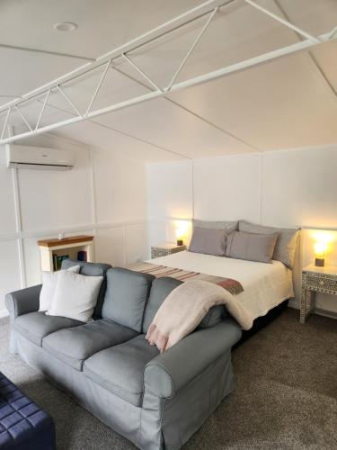 a living room with a couch and a bed at Little Eden in Matamata