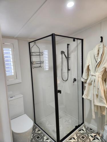 a bathroom with a shower stall and a toilet at Little Eden in Matamata