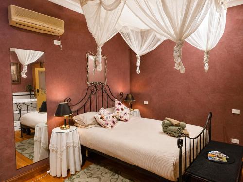 a bedroom with a bed with curtains and a mirror at Charnwood Cottages in Warburton