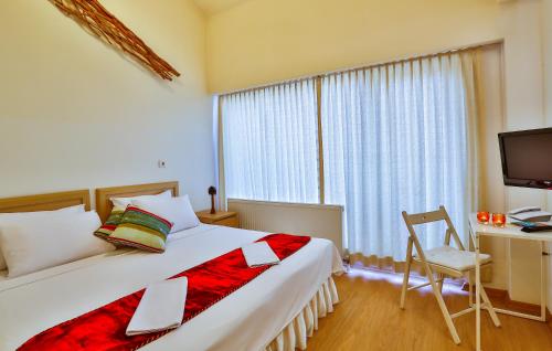 a bedroom with a bed and a desk and a window at Han Hotel Istanbul in Istanbul