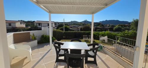a patio with a table and chairs on a balcony at La casa al mare, Pittulongu in Olbia