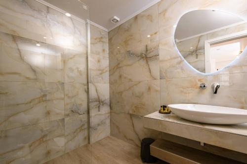 a bathroom with a sink and a mirror at VillAge 1912 Studios in Panagia