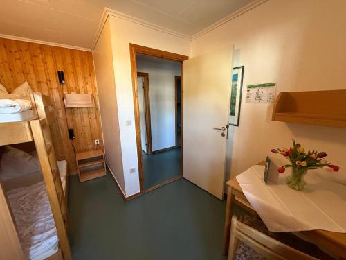 a room with a hallway with a door and a table at martas Gästehäuser Groß Väter See in Templin