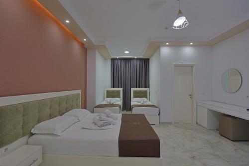 a hospital room with two beds and a sink at Hotel Landi in Ksamil