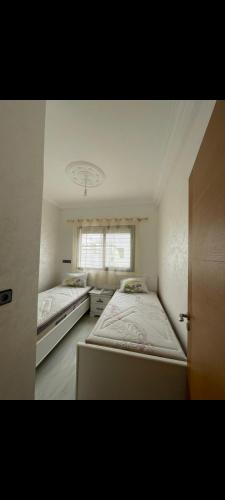 a bedroom with two beds and a window at Mini villa al hoceima in Al Hoceïma