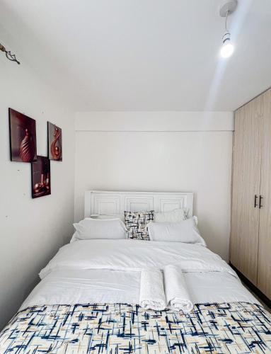 a bedroom with a large white bed with two pillows at The Escape Muthiga Waiyaki way in Nairobi