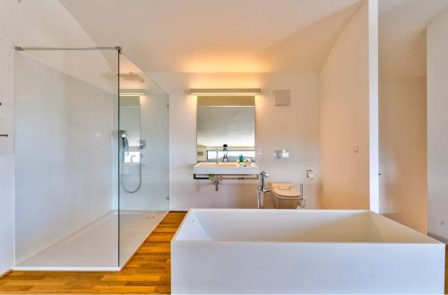 a large white bath tub in a bathroom with a shower at Villa Bambou bei Cannes mit Blick auf Cap Antibes in Vallauris