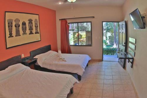 a hotel room with two beds and a window at Pitaya Lodge in Potrero
