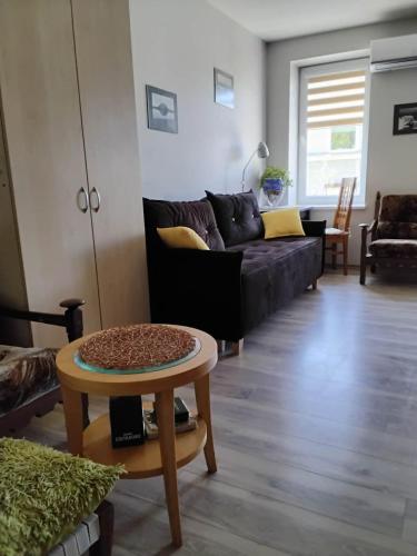 a living room with a black couch and a table at Apartamentai Heydekrug in Šilutė