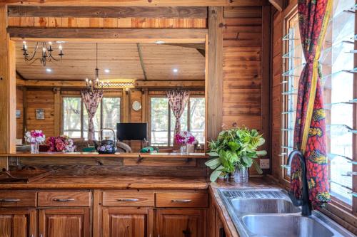 a kitchen with wooden cabinets and a sink at Cliffside Amani Wooden Villa with Stunning Ocean Views for an Authentic Tanzanian Escape in Dar es Salaam