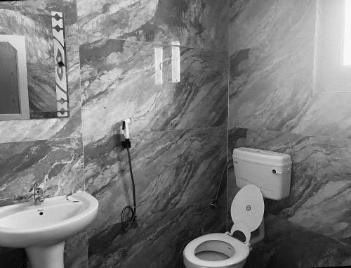 a bathroom with a toilet and a sink at Samoon Guest House in Karnāl