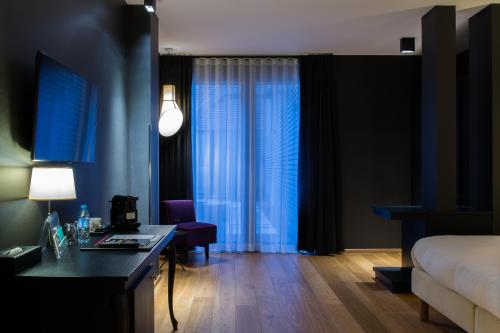 a hotel room with a bed and a desk and a room at Hotel The Royal Snail in Namur