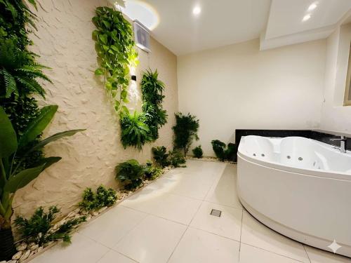 a bathroom with a white tub and plants on the wall at Pyramids Glory Inn in Cairo
