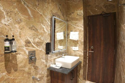 a bathroom with a sink and a mirror at The Park Central in Lucknow