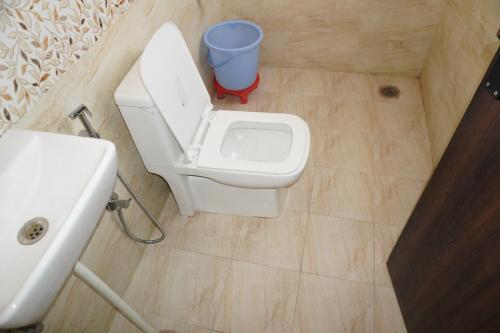 a bathroom with a toilet and a sink and a bucket at Hotel Narayan free Parking & Near Toran Dwar in Khātu