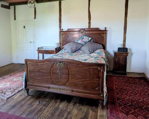 a wooden bed with two pillows on it in a room at Chez Caro in Mourjou