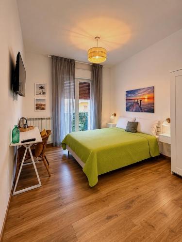 a bedroom with a green bed and a desk at Favola Guesthouse Affittacamere in Nettuno