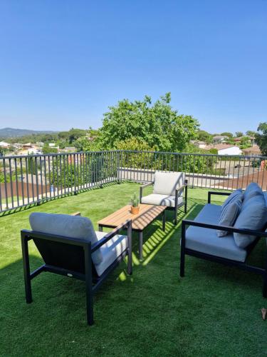a patio with three chairs and a table on the grass at Piscina & BBQ | Cerca Costa Brava in Tordera