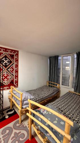 a bedroom with two beds and a window at Crocodile Tash in Tong