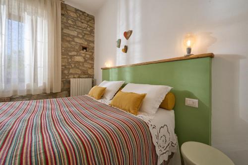 a bedroom with a bed with a green headboard at OlioeAlloro B&B in San Vincenzo