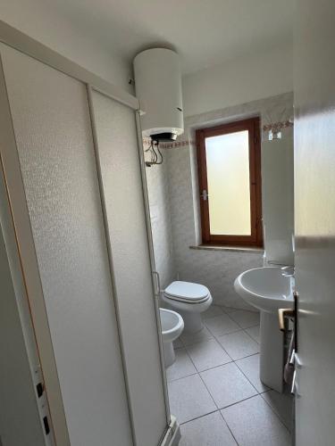 a bathroom with a toilet and a sink at Appartamento Ortensia in Fetovaia