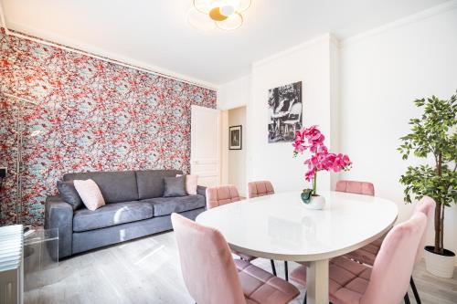 a living room with a table and a couch at Lys Appart in Reims