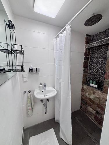 a white bathroom with a sink and a shower at Tiny house with charm in Bremen