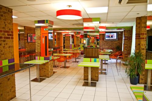 a restaurant with tables, chairs, and tables in it at Ibis Styles London Walthamstow in London