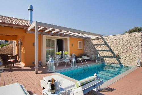 a house with a swimming pool and a patio at Litohoro Olympus Resort Villas & Spa in Plaka Litochorou