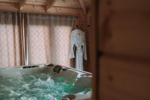 eine Badewanne, an deren Fenster ein Bademantel hängt in der Unterkunft Chalet Oz Vitznau with Lake Lucerne Views in Vitznau