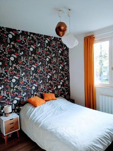 a bed in a bedroom with a wall covered in stickers at Maison paisible en lisière de foret 9 personnes in Le Temple
