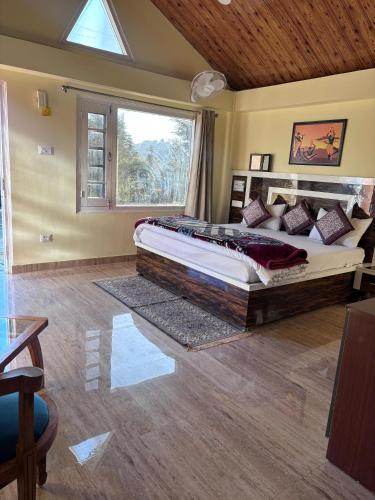 a bedroom with a large bed and a window at The Hideaway Chail in Chail