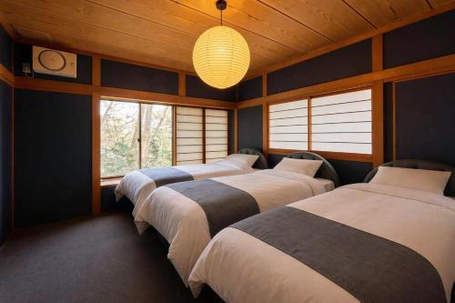 a row of four beds in a room with windows at NASU Fir Tree in Nasu