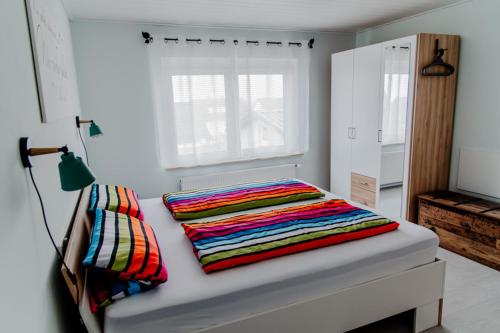 a bed with two colorful pillows on top of it at Ferienwohnung Münch mit Balkon in Großheubach
