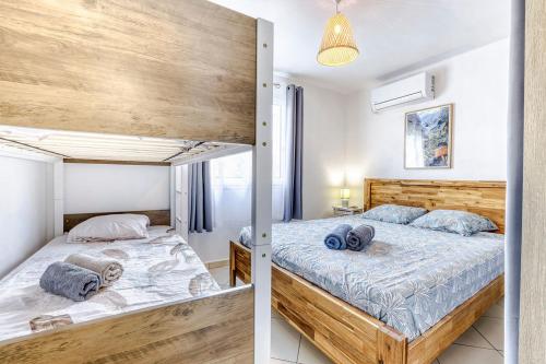 a bedroom with a bunk bed with blue pillows on it at Villa Cardinal in Saint-Louis