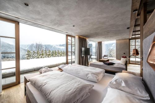 a bedroom with two beds and a large window at Ansitz Velseck-Residence Hotel in Tires