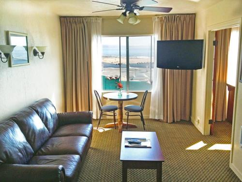 a living room with a couch and a table and a television at Capitola Venetian Vacation Rentals in Capitola