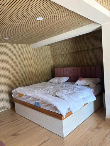a large bed in a room with avertisement at Oliway Homestay in Lohaghāt
