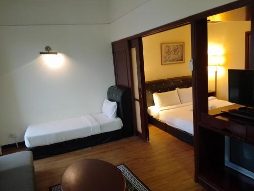 a hotel room with two beds and a television at Elevate suite Hotel time square kl in Kuala Lumpur