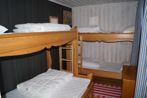 a bedroom with two bunk beds with white sheets at Värmlandsstugan in Sälen