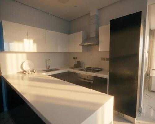 a kitchen with white cabinets and a black refrigerator at Al Safwa One in Al Ḩadd