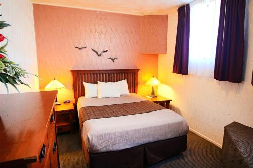 a hotel room with a bed and two birds on the wall at Capitola Venetian Vacation Rentals in Capitola