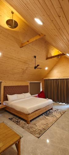 a bedroom with a large bed in a wooden ceiling at Karibu Karjat Resort in Karjat