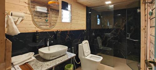 a bathroom with a toilet and a sink and a shower at Karibu Karjat Resort in Karjat