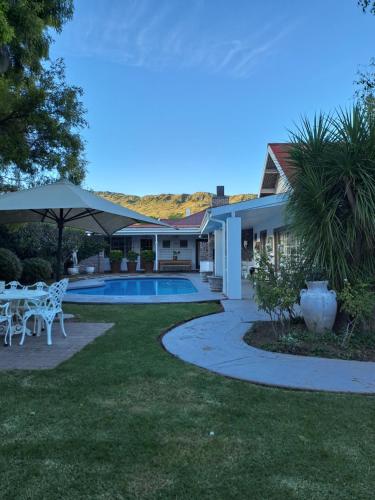 a house with a patio and a swimming pool at Meerlin Guest House in Queenstown