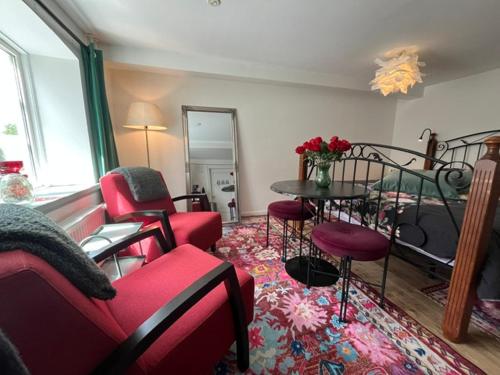 a living room with red chairs and a table at BeBaBopS Homestay Sønderborg in Sønderborg