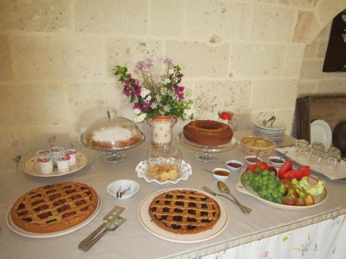 a table topped with pies and fruit on top at Masseria Giustiniani in Torricella