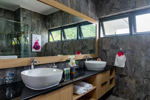a bathroom with two sinks and two mirrors at Fairview Heights in Victoria