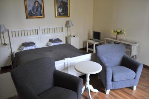 a bedroom with a bed and a couch and a chair at Zamek Rynkówka in Rynkówka