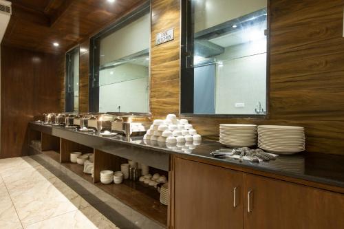 a kitchen with a counter with plates and mirrors at Hotel Aroma Suites Delhi - With Free Airport Drop in New Delhi